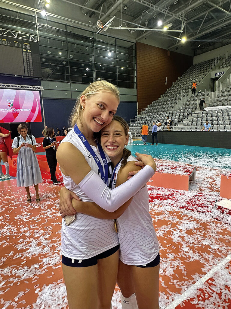 Timothy Christian’s Abby Vander Wal and Immaculate Conception’s Ava Falduto hug after winning a world championship in volleyball.