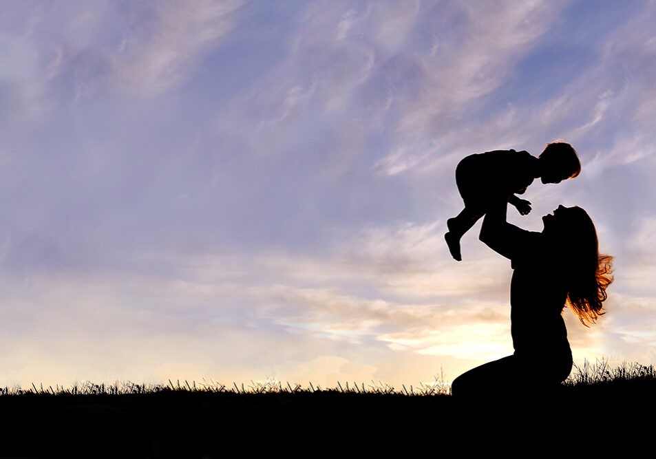 Silhouette of Happy Mother Playing Outside with Baby
